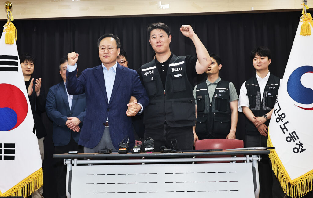20일 경기도 수원시 장안구 경기고용노동청에서 열린 삼성전자 임금협상을 마친 후 여명구 삼성전자 DS(디바이스솔루션·반도체 사업 담당) 피플팀장과 최승호 삼성그룹 초기업노동조합 삼성전자지부 위원장이 잠정 합의안에 서명한 후 파이팅을 외치고 있다.